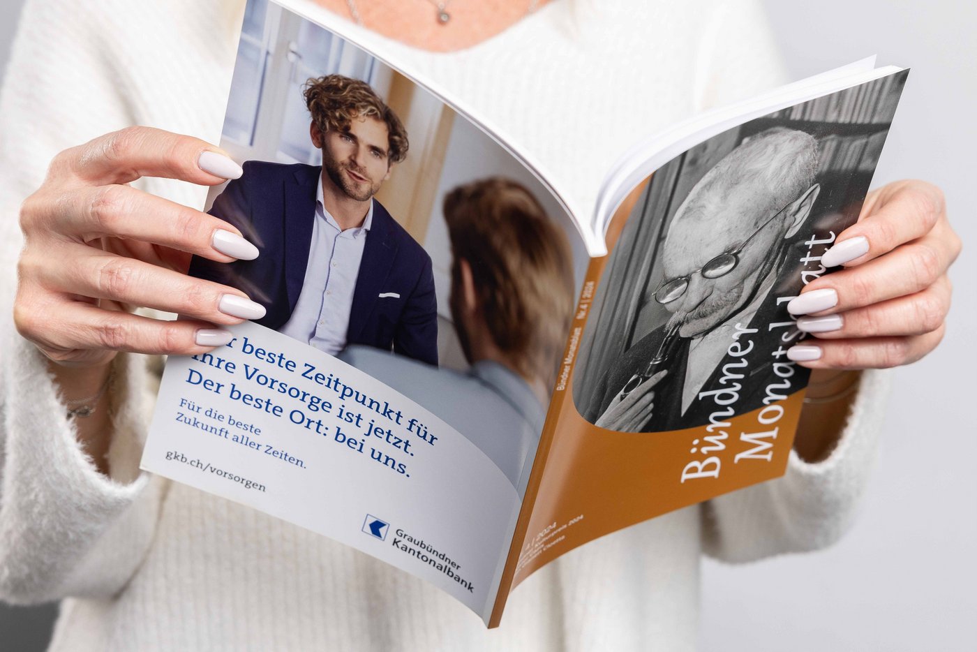 Nahaufnahme einer Person, welche das Bündner Monatsblatt in den Händen hält.