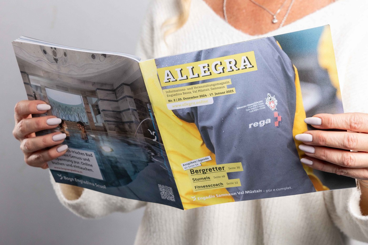 Nahaufnehme von zwei Händen, welche ein Allegra-Magazin in den Händen hält.
