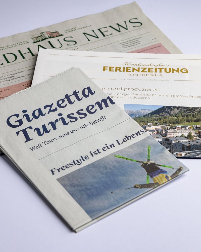 Eine Studiofotografie von diversen Zeitungen wie Waldhaus News oder Giazetta Turissem oder die Ferienzeitung des Hotel Albris