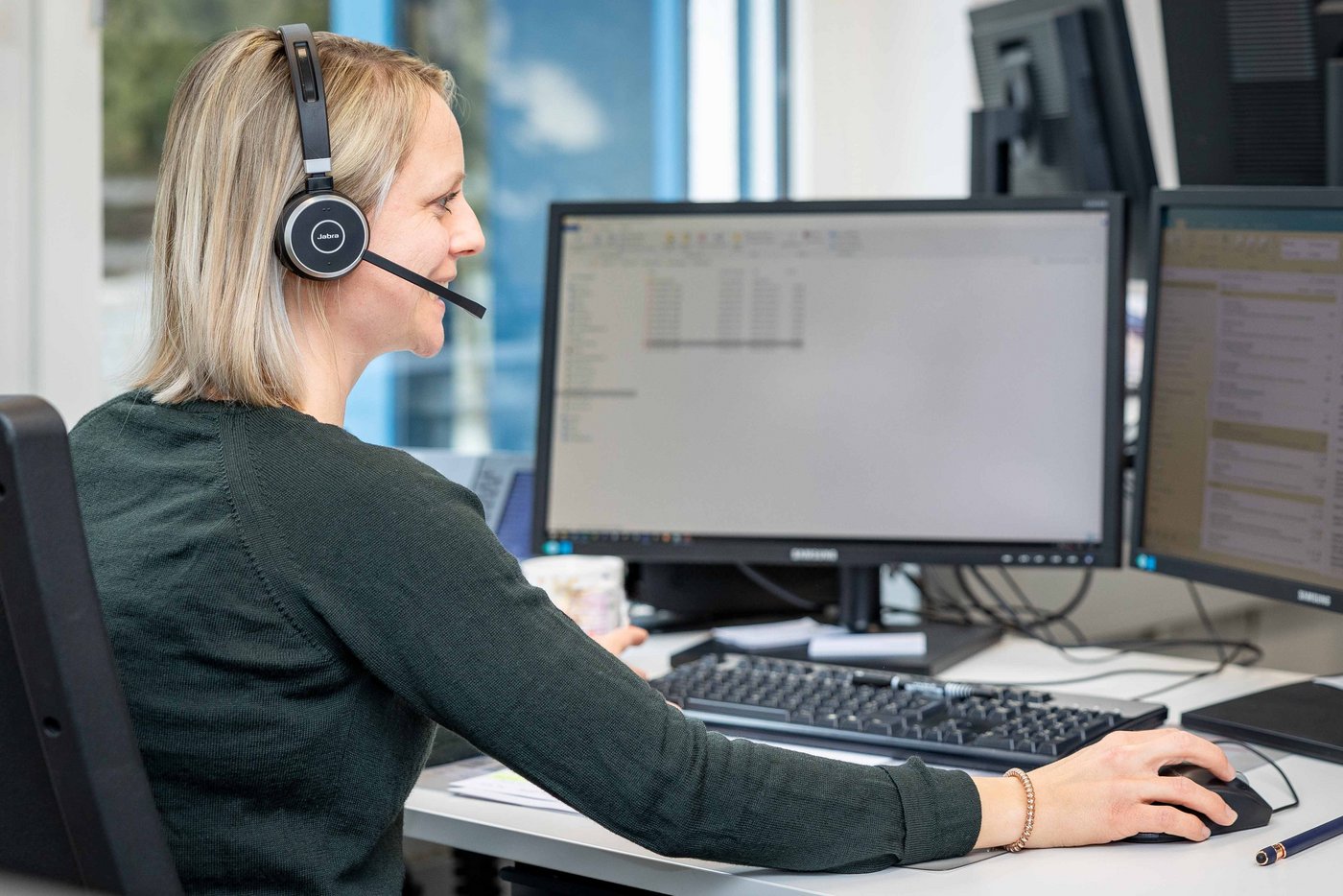 Portrait Fotografie einer Kundenberaterin von Hinten. Die Beraterin ist am telefonieren.